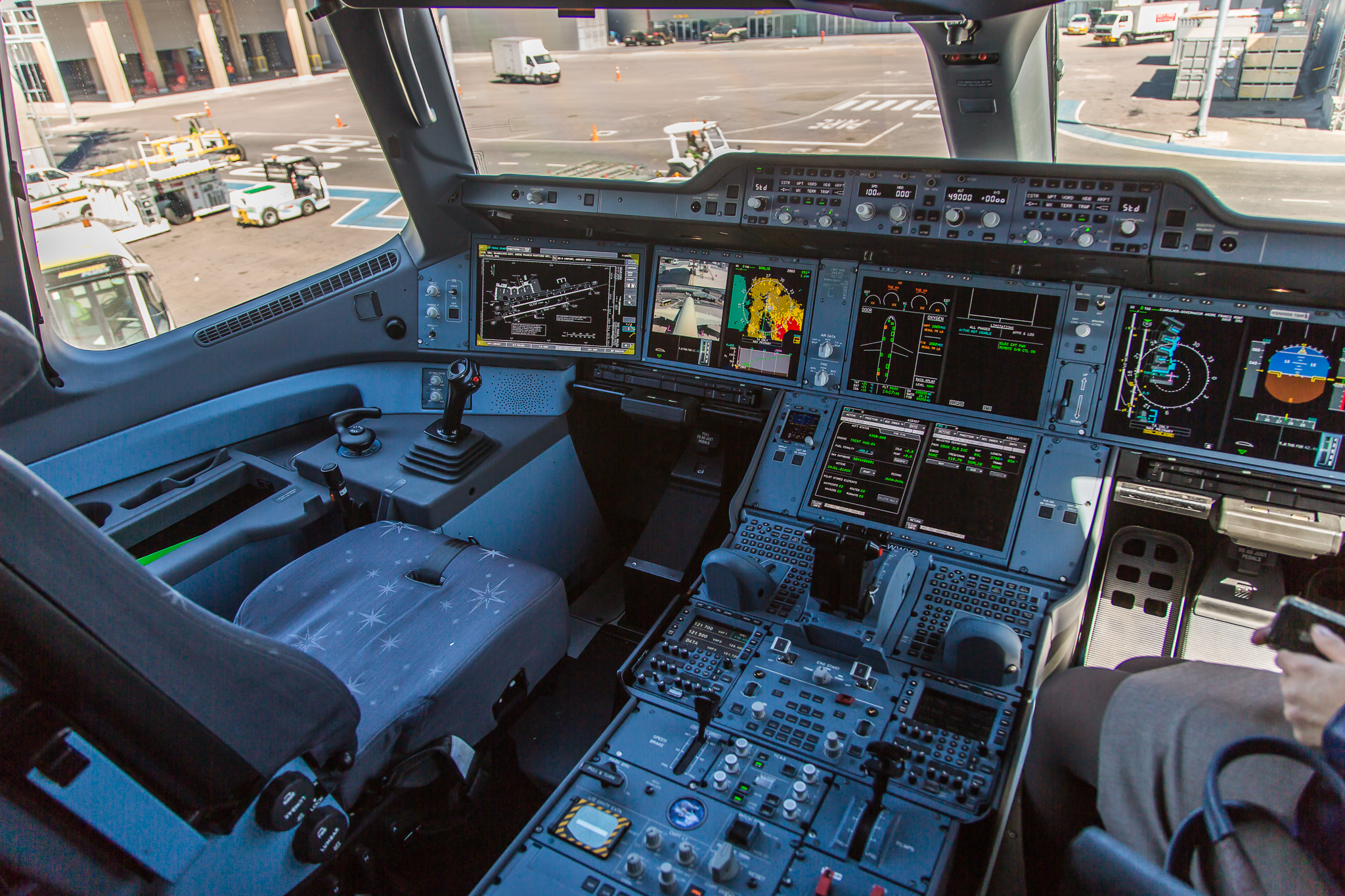 Airbus A350 flight deck with multiple electronic displays and pilot controls.
